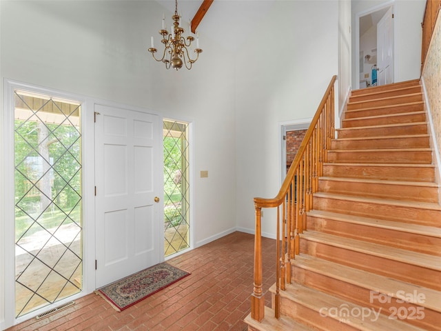 80 Gobblers Knob Dr, Clyde, NC 28721 - foyer entrance featuring brick flooring, a high ceiling, stairs, and a chandelier