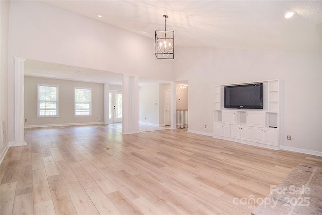 9117 Castle Garden Ln, Charlotte, NC 28215 - unfurnished living room with a chandelier, light wood-style flooring, a towering ceiling, and recessed lighting