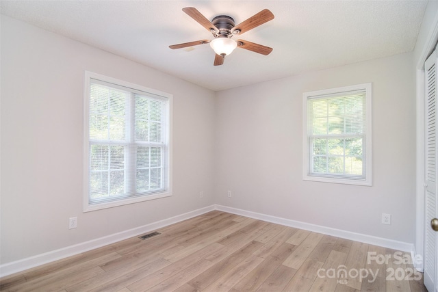 9117 Castle Garden Ln, Charlotte, NC 28215 - unfurnished bedroom with light wood finished floors, multiple windows, a closet, and ceiling fan