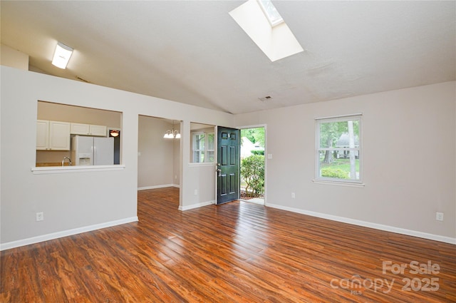 5424 Amado St, Charlotte, NC 28215 - unfurnished room with a chandelier, wood finished floors, a skylight, and lofted ceiling