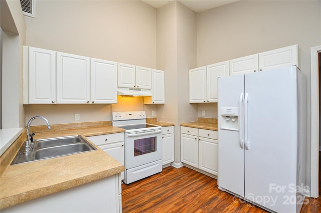 5424 Amado St, Charlotte, NC 28215 - kitchen featuring white appliances, under cabinet range hood, a high ceiling, dark wood-type flooring, and white cabinets