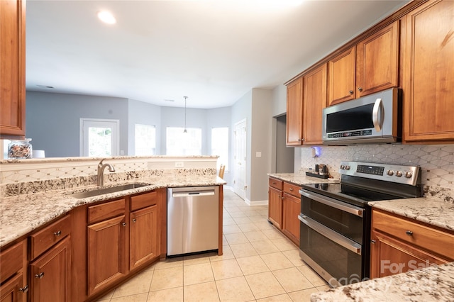 219 Harrowfield Hts, York, SC 29745 - kitchen with stainless steel appliances, tasteful backsplash, brown cabinets, light tile patterned flooring, and light stone countertops