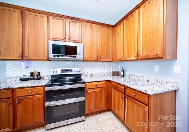219 Harrowfield Hts, York, SC 29745 - kitchen featuring stainless steel appliances, brown cabinets, backsplash, and light tile patterned floors