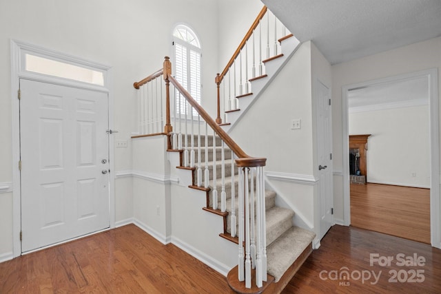 9121 Four Acre Ct, Charlotte, NC 28210 - entrance foyer featuring wood finished floors, stairway, healthy amount of natural light, and a fireplace with raised hearth