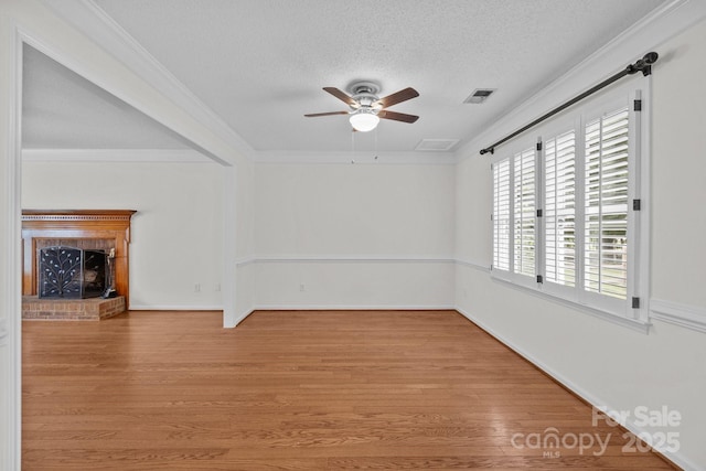 9121 Four Acre Ct, Charlotte, NC 28210 - unfurnished living room with a ceiling fan, light wood finished floors, a fireplace, a textured ceiling, and ornamental molding