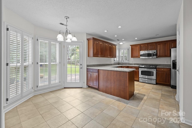 9121 Four Acre Ct, Charlotte, NC 28210 - kitchen featuring appliances with stainless steel finishes, a chandelier, a textured ceiling, a peninsula, and pendant lighting