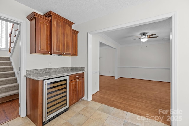 9121 Four Acre Ct, Charlotte, NC 28210 - bar featuring beverage cooler, stairway, a ceiling fan, a textured ceiling, and light wood-type flooring