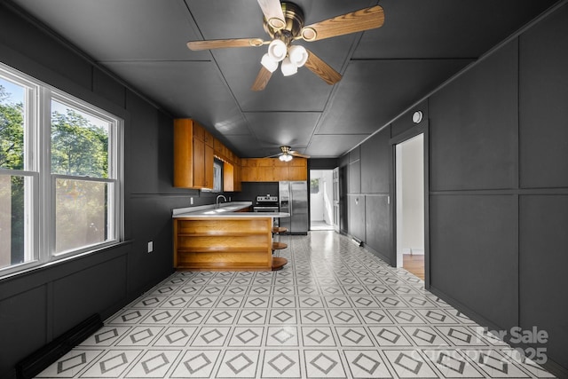 109 Short St, Waynesville, NC 28786 - kitchen with appliances with stainless steel finishes, a decorative wall, ceiling fan, a peninsula, and brown cabinets