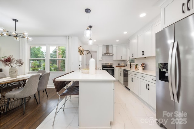 4017 Sulkirk Rd, Charlotte, NC 28210 - kitchen with stainless steel appliances, wall chimney exhaust hood, light countertops, a kitchen island, and decorative backsplash