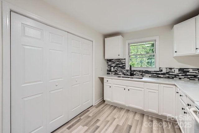 1224 E Woodlawn Rd, Charlotte, NC 28209 - kitchen featuring tasteful backsplash, light countertops, and white cabinetry