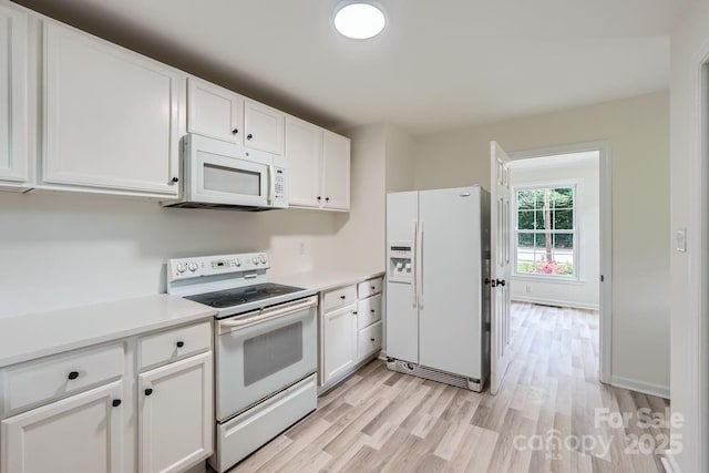 1224 E Woodlawn Rd, Charlotte, NC 28209 - kitchen featuring white appliances, light wood-style floors, white cabinets, and light countertops