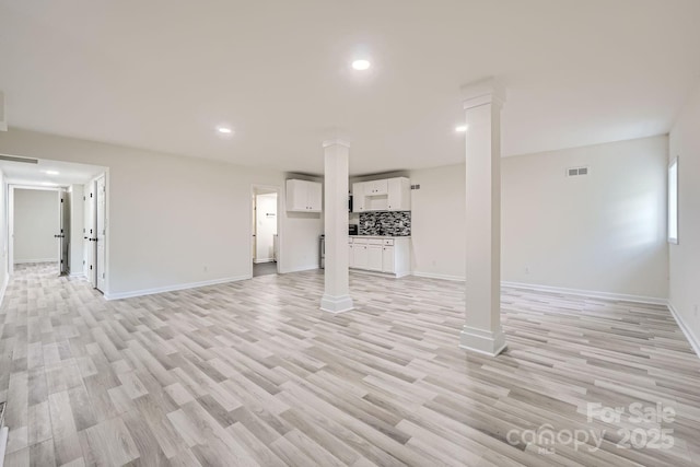 1224 E Woodlawn Rd, Charlotte, NC 28209 - unfurnished living room with ornate columns, light wood-style flooring, and recessed lighting