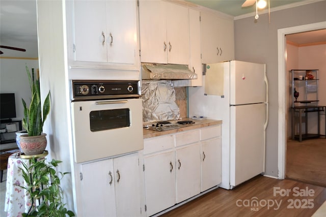 405 Wesley Heights Dr, Albemarle, NC 28001 - kitchen featuring white appliances, ceiling fan, under cabinet range hood, crown molding, and wood finished floors