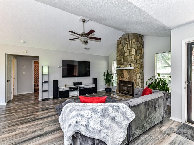 5105 Hampton Meadows Rd, Monroe, NC 28110 - living area with wood finished floors, vaulted ceiling, ceiling fan, a textured ceiling, and a stone fireplace