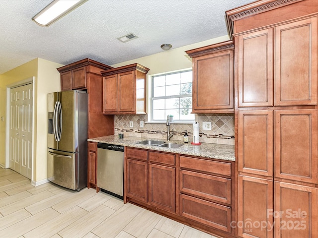 5105 Hampton Meadows Rd, Monroe, NC 28110 - kitchen featuring appliances with stainless steel finishes, decorative backsplash, light stone countertops, brown cabinetry, and light wood-type flooring