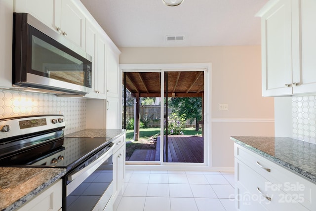 5806 Autumn Trace Ln, Indian Trail, NC 28079 - kitchen featuring stainless steel appliances, tasteful backsplash, white cabinets, light tile patterned floors, and dark stone countertops