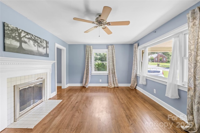 506 Gold St, Shelby, NC 28150 - unfurnished living room with wood finished floors, a tiled fireplace, and ceiling fan