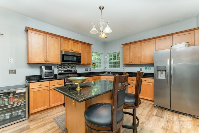 7218 Cascading Pines Dr, Fort Mill, SC 29708 - kitchen featuring stainless steel appliances, wine cooler, light wood-style flooring, and a chandelier