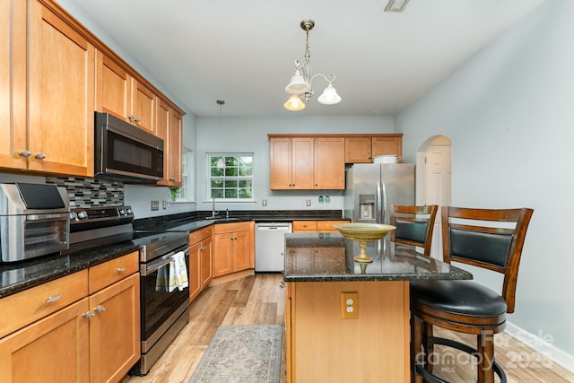 7218 Cascading Pines Dr, Fort Mill, SC 29708 - kitchen with appliances with stainless steel finishes, light wood-style flooring, a center island, and a kitchen bar