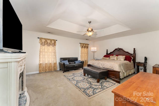 7218 Cascading Pines Dr, Fort Mill, SC 29708 - bedroom with a raised ceiling, light colored carpet, a ceiling fan, and a fireplace