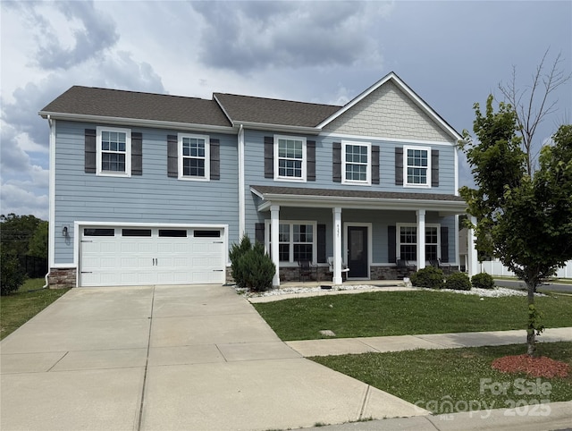 4357 Hornyak Dr, Monroe, NC 28110 - view of front of home with concrete driveway, covered porch, a front yard, an attached garage, and stone siding