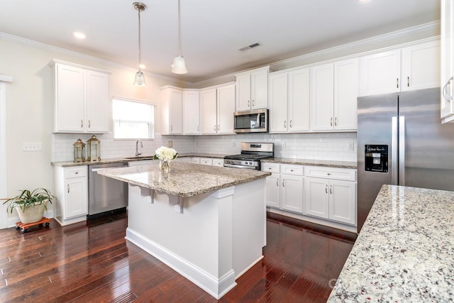 4357 Hornyak Dr, Monroe, NC 28110 - kitchen with appliances with stainless steel finishes, white cabinets, a center island, backsplash, and dark wood-style flooring