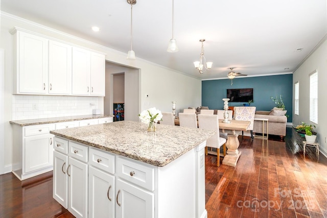 4357 Hornyak Dr, Monroe, NC 28110 - kitchen featuring dark wood-type flooring, a kitchen island, open floor plan, crown molding, and white cabinets