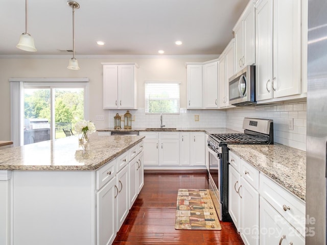 4357 Hornyak Dr, Monroe, NC 28110 - kitchen with appliances with stainless steel finishes, a kitchen island, decorative backsplash, healthy amount of natural light, and crown molding