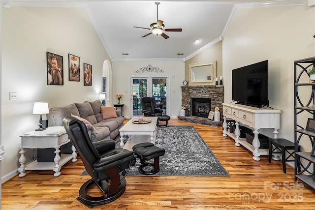 1622 Brookstone Dr, Hickory, NC 28602 - living area with ornamental molding, ceiling fan, arched walkways, light wood finished floors, and a stone fireplace