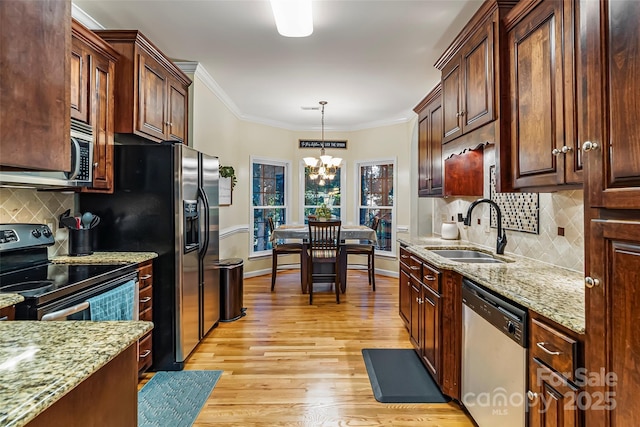 1622 Brookstone Dr, Hickory, NC 28602 - kitchen with stainless steel appliances, a chandelier, light wood finished floors, crown molding, and backsplash