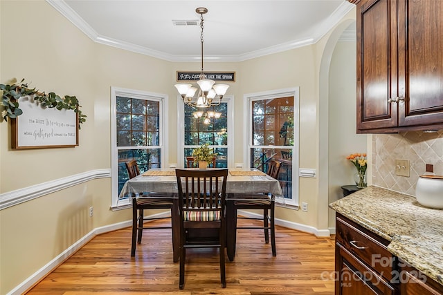 1622 Brookstone Dr, Hickory, NC 28602 - dining space featuring a chandelier, light wood-style flooring, ornamental molding, and arched walkways