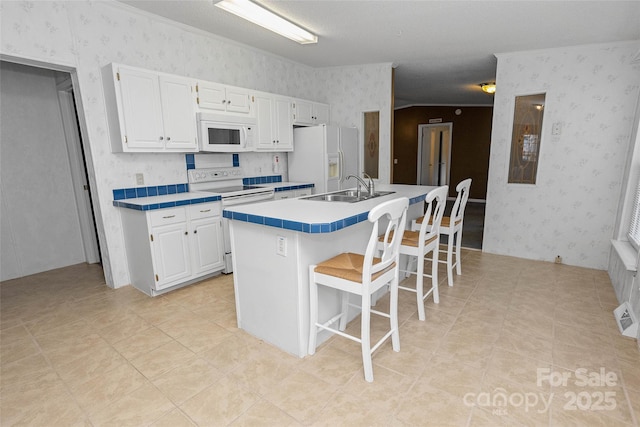 56 Founders Way, Arden, NC 28704 - kitchen featuring white appliances, wallpapered walls, white cabinets, a kitchen bar, and a center island with sink