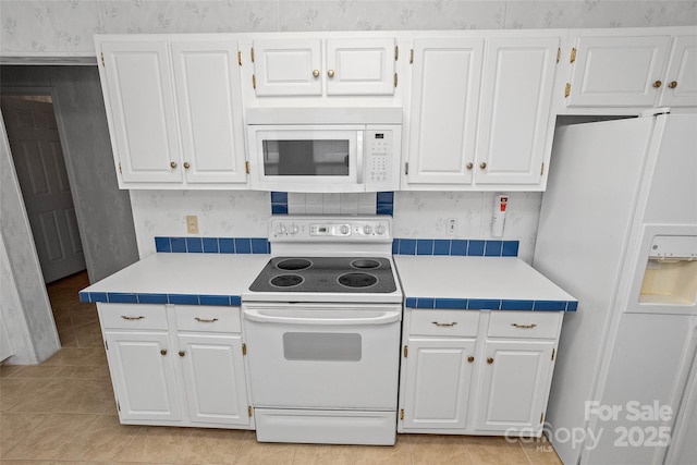 56 Founders Way, Arden, NC 28704 - kitchen featuring white appliances, wallpapered walls, white cabinets, light tile patterned floors, and tile countertops