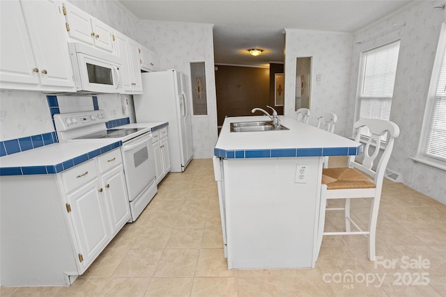 56 Founders Way, Arden, NC 28704 - kitchen featuring white appliances, wallpapered walls, a kitchen breakfast bar, white cabinetry, and light tile patterned floors