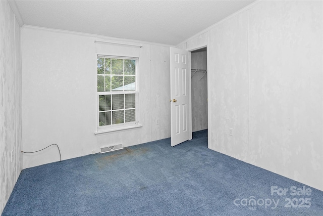 56 Founders Way, Arden, NC 28704 - unfurnished bedroom featuring crown molding, carpet flooring, a spacious closet, and a textured ceiling