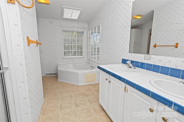 56 Founders Way, Arden, NC 28704 - bathroom with wallpapered walls, double vanity, a garden tub, tile patterned flooring, and a textured ceiling
