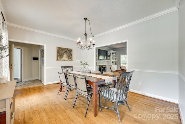 675 Ormand Rd, York, SC 29745 - dining space featuring light wood-style flooring, a chandelier, crown molding, and a fireplace