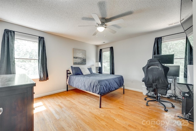 675 Ormand Rd, York, SC 29745 - bedroom with multiple windows, light wood-style floors, a textured ceiling, a desk, and a ceiling fan