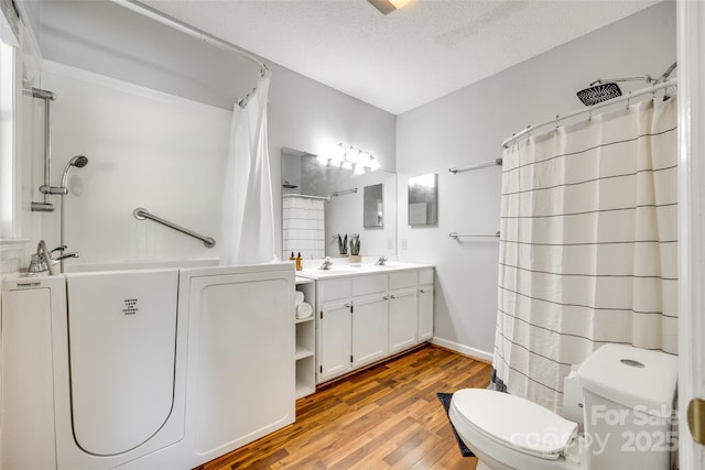 675 Ormand Rd, York, SC 29745 - bathroom featuring washer / dryer, double vanity, wood finished floors, curtained shower, and a textured ceiling