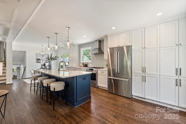 3165 Pendleton Ave, Charlotte, NC 28210 - kitchen with appliances with stainless steel finishes, wall chimney exhaust hood, dark wood finished floors, light countertops, and recessed lighting