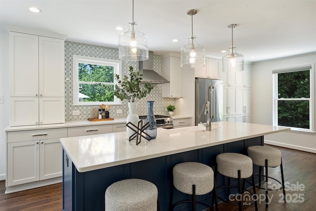 3165 Pendleton Ave, Charlotte, NC 28210 - kitchen with wall chimney range hood, stainless steel appliances, dark wood-style floors, decorative backsplash, and light countertops