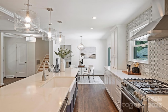 3165 Pendleton Ave, Charlotte, NC 28210 - kitchen with wall chimney exhaust hood, stainless steel range with gas cooktop, dark wood finished floors, light countertops, and recessed lighting