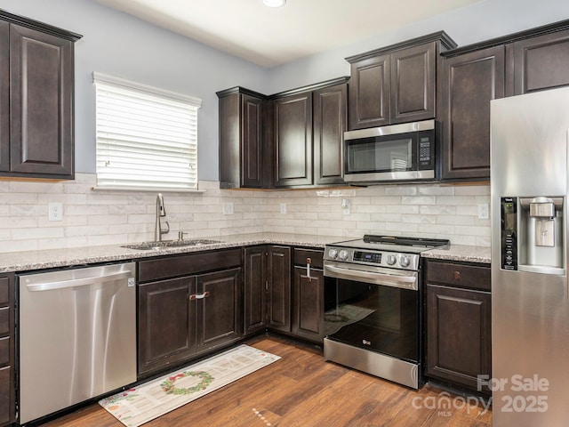 9123 Magnolia Lily Ave, Charlotte, NC 28227 - kitchen with appliances with stainless steel finishes, dark brown cabinets, decorative backsplash, and light stone countertops