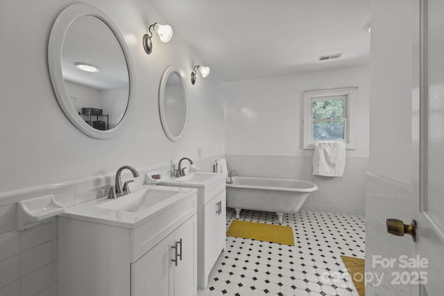 114 Windchime Ln, Mooresville, NC 28115 - bathroom with tile walls, tile patterned floors, vanity, wainscoting, and a soaking tub