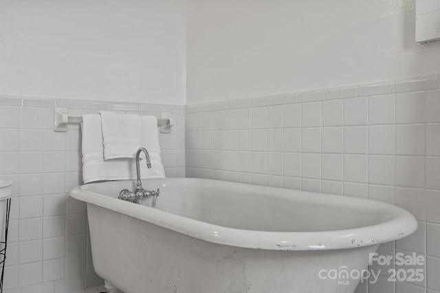 114 Windchime Ln, Mooresville, NC 28115 - bathroom with tile walls, a freestanding bath, and a wainscoted wall