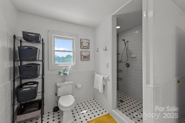 114 Windchime Ln, Mooresville, NC 28115 - bathroom with tile walls, a tile shower, and a wainscoted wall
