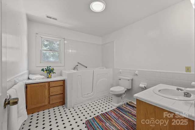 114 Windchime Ln, Mooresville, NC 28115 - full bathroom with tile walls, a bath, vanity, and a wainscoted wall