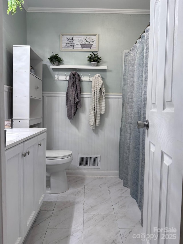 605 Impala Dr, Albemarle, NC 28001 - bathroom with marble look tiles, vanity, a wainscoted wall, and ornamental molding