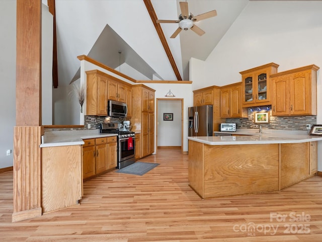 887 Living Waters Dr, Great Falls, SC 29055 - kitchen with stainless steel appliances, a peninsula, high vaulted ceiling, light wood-type flooring, and backsplash