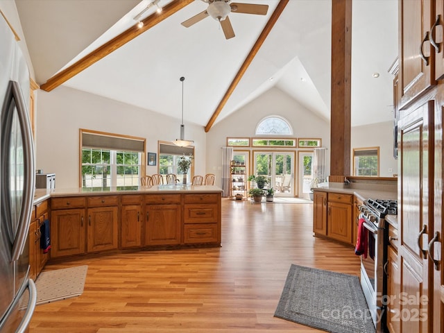 887 Living Waters Dr, Great Falls, SC 29055 - kitchen with stainless steel appliances, brown cabinetry, light wood-style flooring, high vaulted ceiling, and light countertops
